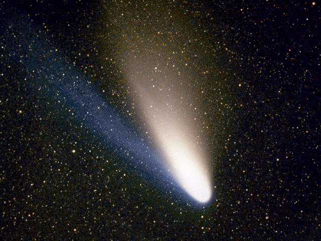 Figura 3: la splendida cometa Hale-Bopp (1997). Il moto della coda di ioni, di colore azzurro, è causato dalla pressione di radiazione del Sole (crediti: Geoff Chester, immagine di pubblico dominio via Wikimedia Commons).