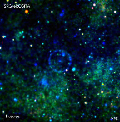 Fig. 6 - Il cerchio blu al centro di questa immagine è stato prodotto dalla riflessione di un lampo di raggi X prodotto dalla materia che cade in un buco nero. Infatti, un anno prima del lancio di eRosita, un altro telescopio X aveva osservato un aumento improvviso dell’emissione da questa sorgente (indicata come X-ray transient in figura). Questi raggi X hanno raggiunto una nube di gas, che li ha riflessi verso di noi, producendo l’anello che vediamo: una eco dello scoppio. Crediti: Georg Lamer (Leibniz-Institut für Astrophysik Potsdam), Davide Mella.
