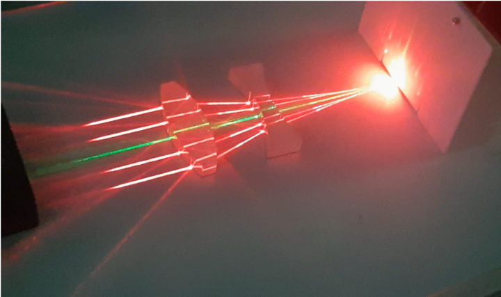 Fig. 5 - Concentrazione di raggi di luce laser tramite rifrazione, usando lenti - Fotografia fatta durante lo stage PCTO 2023 Laboratorio di Ottica, in collaborazione con Bianca Salmaso e Andrea Bianco, INAF-Brera.